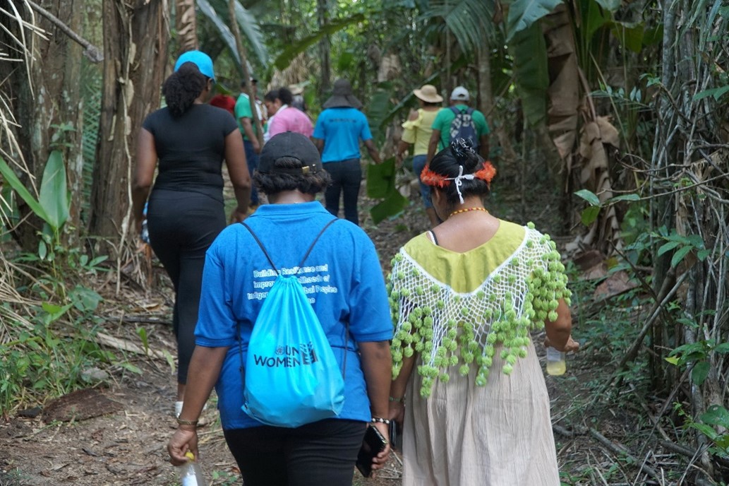 Picture of Permanent Secretary Pavion Hermien, Directorate of Agriculture (left) and Chief Wendy Sabajo (right) along with delegation members trekking to the pineapple field in Matta