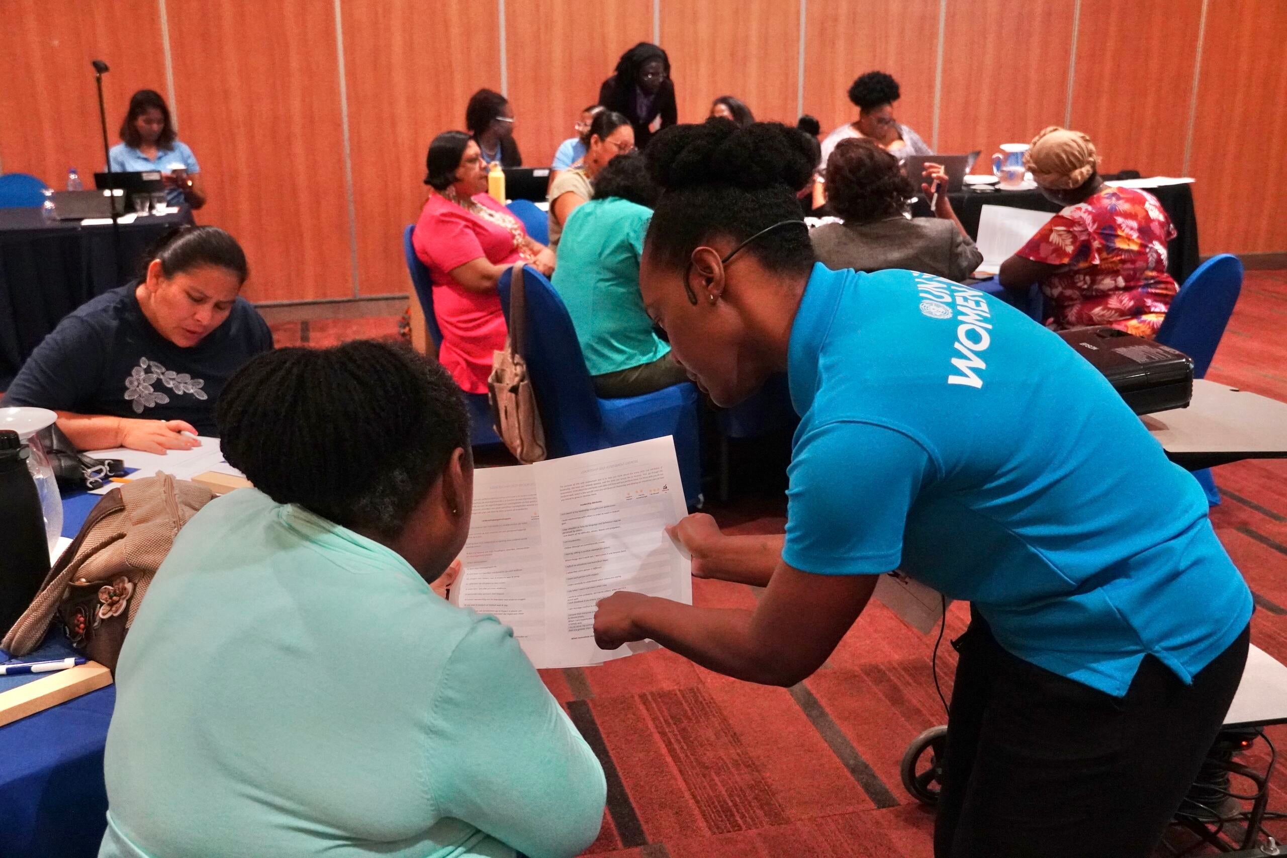 UN Women MCO – Caribbean staff member assists a participant during an exercise