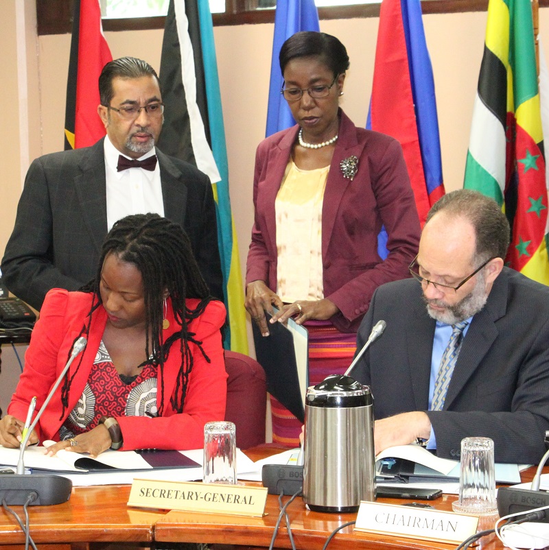 Seated, from left, UN Women Head of Office, Ms. Tonni Brodber, and CARICOM Secretary-General, Ambassador Irwin LaRocque sign the MOU. Standing are Mr. Neville Bissember and Ms. Barbara Vandyke, Office of the CARICOM Secretary-General. Photo compliments of CARICOM